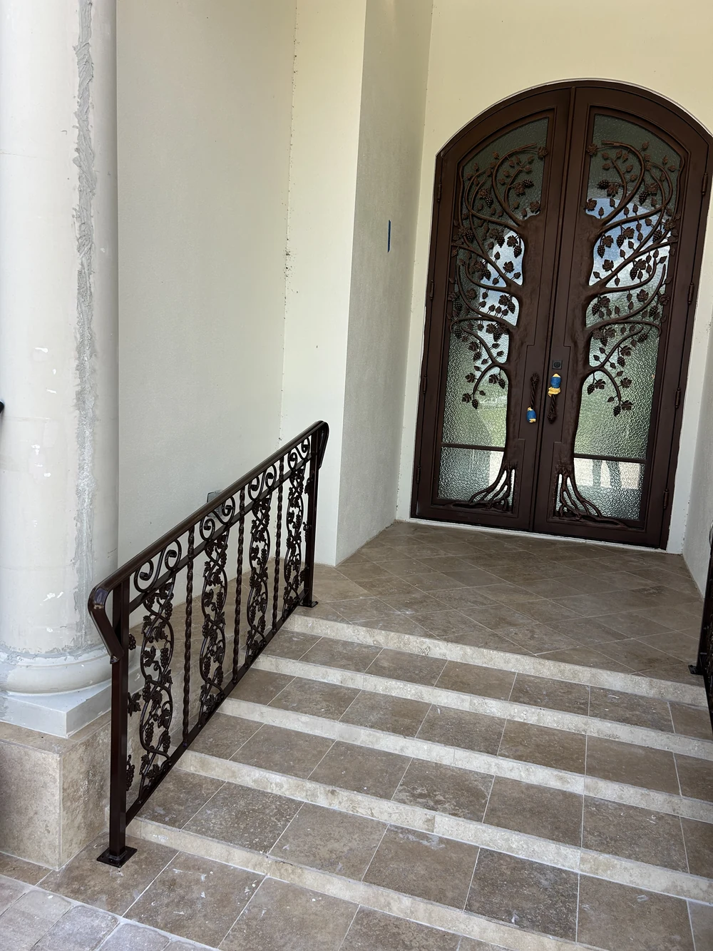 Finished decorative handrail installed at a tiled entrance