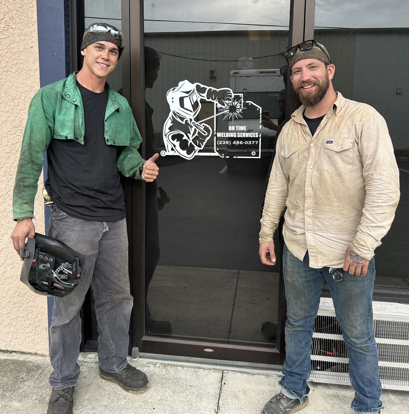 Two On Time Welding team members outside the workshop